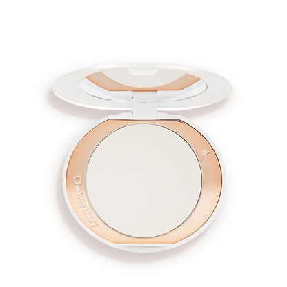 An open, setting powder compact with a mirrored-lid and white and gold-coloured packaging.