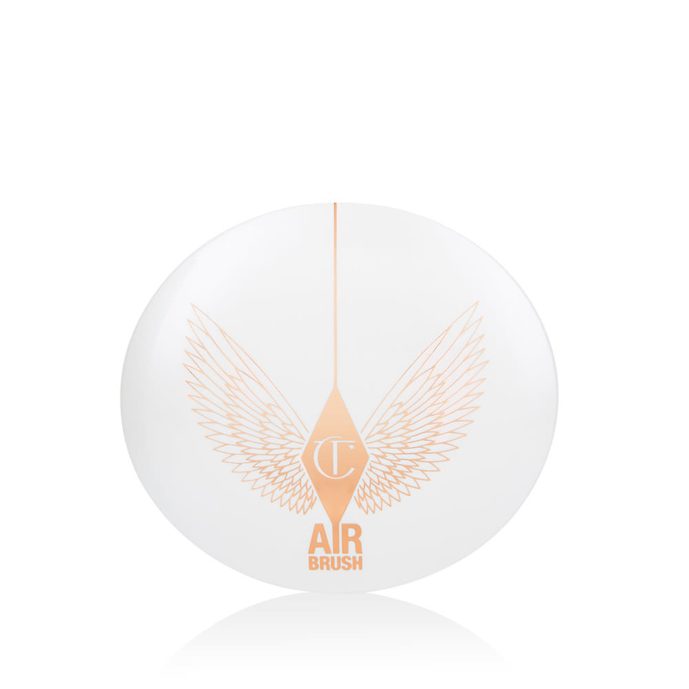 A closed, setting powder compact with a white-coloured lid with golden-coloured wings on it.