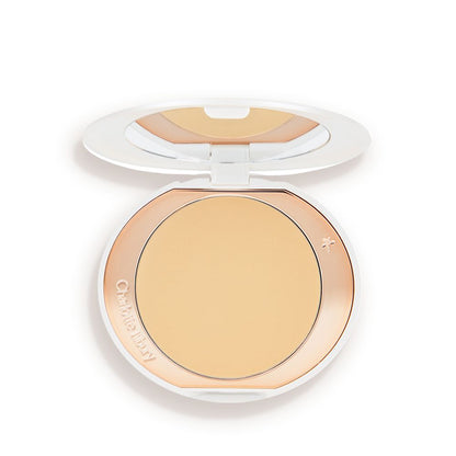 An open, setting powder compact with a mirrored-lid and white and gold-coloured packaging.