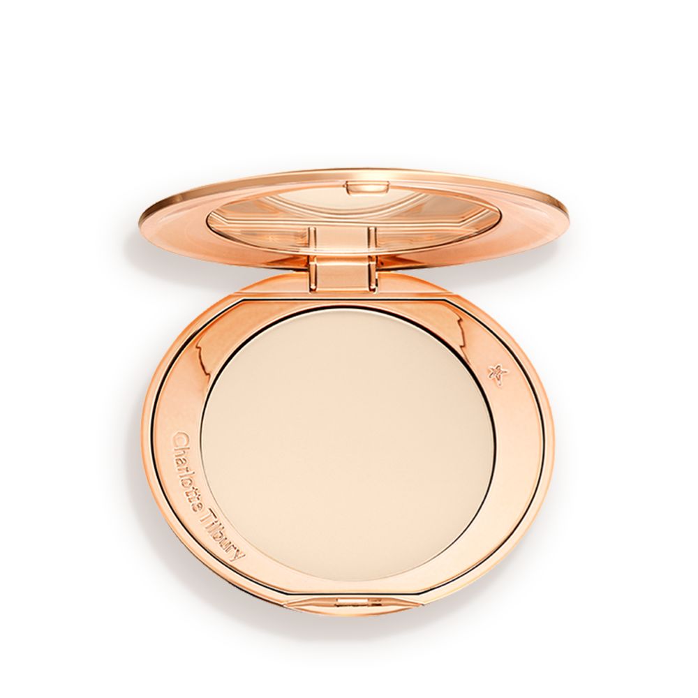 An open, pressed powder compact in a cream colour.
