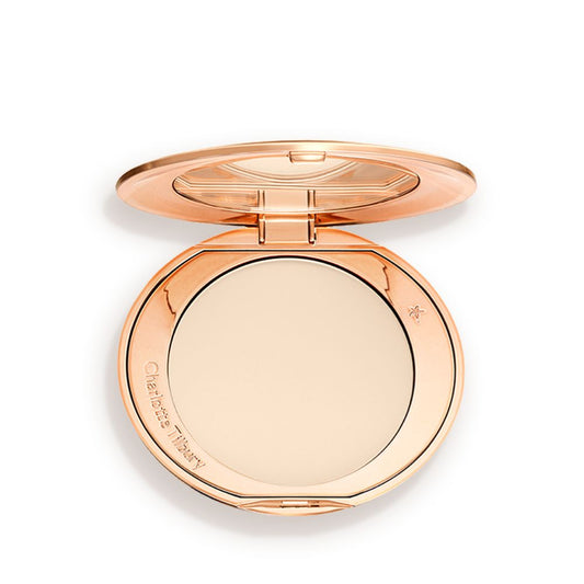 An open, pressed powder compact in a cream colour.