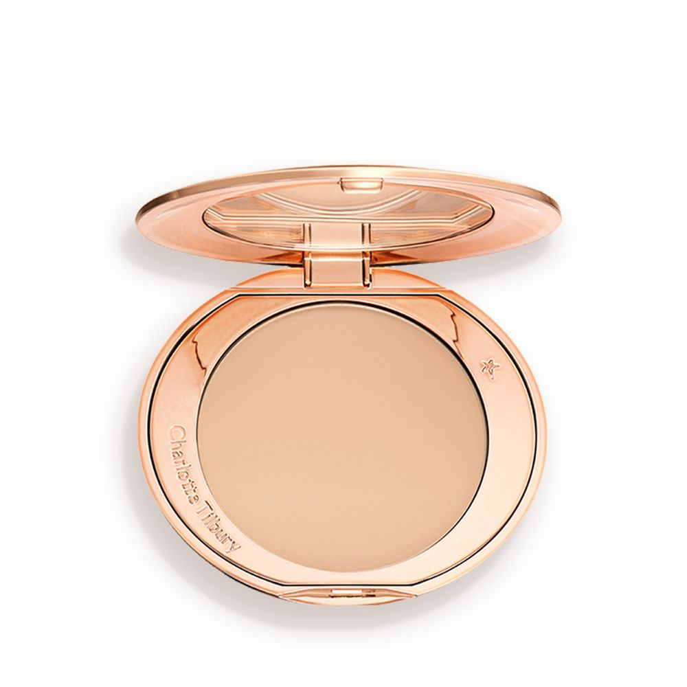An open, pressed powder compact in a light beige shade.
