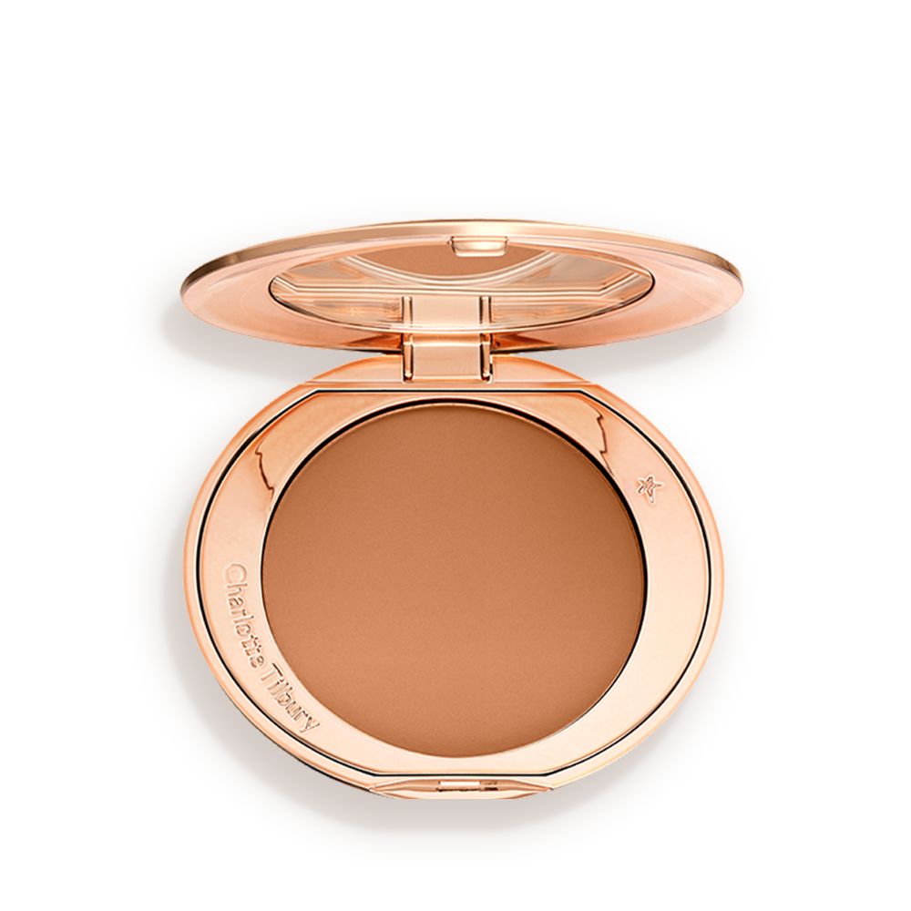 An open, pressed powder compact in a dark brown shade.