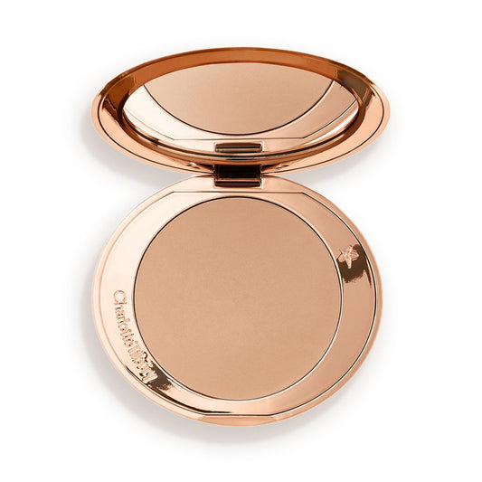 An open mirrored-lid bronzer compact in a light shade.