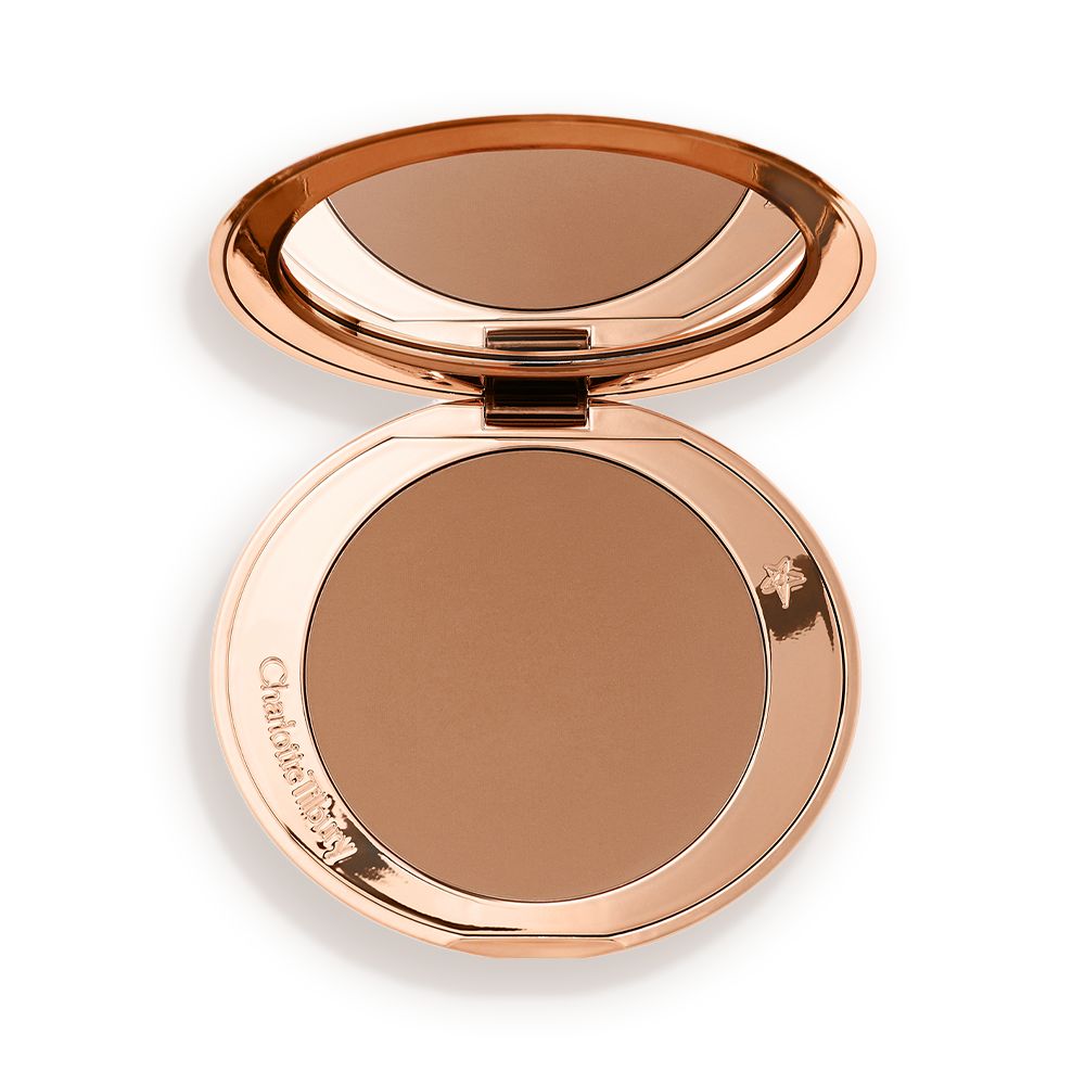 An open mirrored-lid bronzer compact in a medium-brown shade.