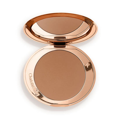 An open mirrored-lid bronzer compact in a medium-brown shade.