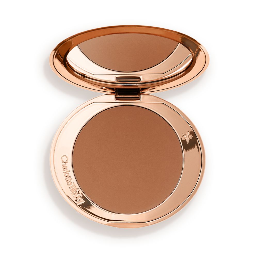 An open mirrored-lid bronzer compact in a tan shade.