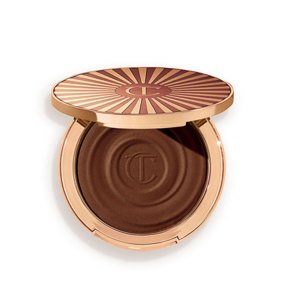 Open, cream bronzer compact in a black-brown shade with gold-coloured packaging.