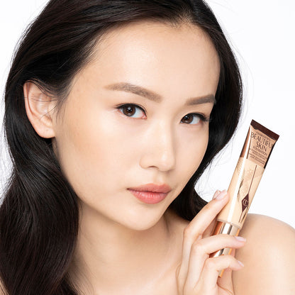 Fair-tone brunette model wearing glowy, skin-like foundation with a satin finish with nude lipstick and subtle eye makeup.