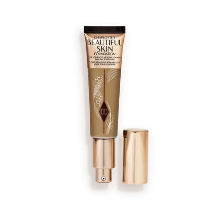 An open foundation wand in gold packaging with a pump dispenser and a dark-sandy-brown-coloured body to show the shade of the foundation inside.