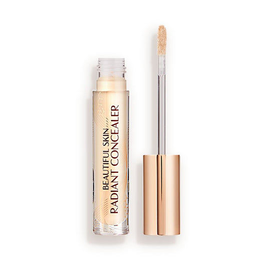 Light beige radiant concealer in a glass tube with its gold-coloured lid with a doe-foot end next to it, and text on the tube that reads, 'Beautiful Skin Concealer'