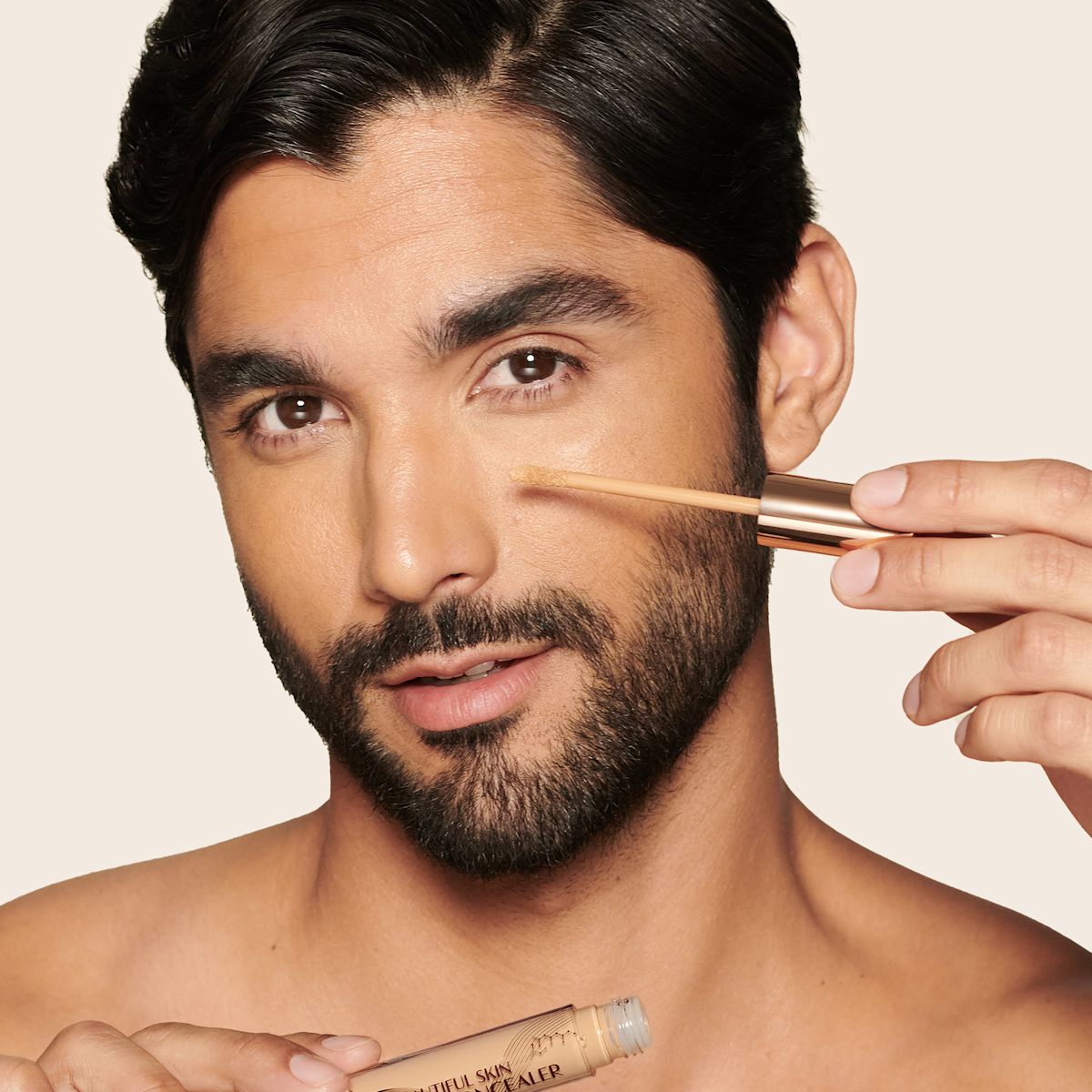 Medium-tone model with brown eyes wearing a radiant, concealer that brightens, covers blemishes, and makes her skin look fresh along with nude lip gloss and subtle eye makeup.