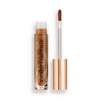 Dark brown radiant concealer in a glass tube with its gold-coloured lid with a doe-foot end next to it, and text on the tube that reads, 'Beautiful Skin Concealer'