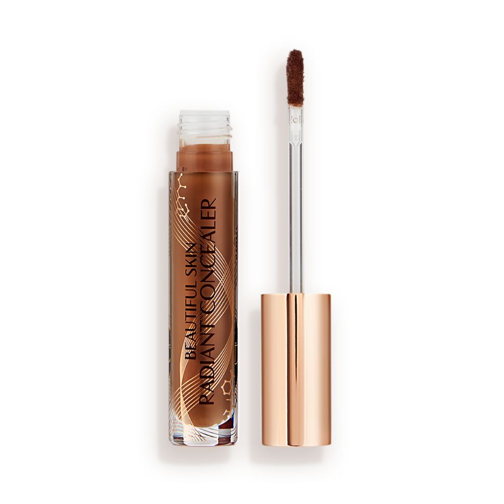 Dark brown radiant concealer in a glass tube with its gold-coloured lid with a doe-foot end next to it, and text on the tube that reads, 'Beautiful Skin Concealer'