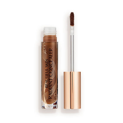 Dark brown radiant concealer in a glass tube with its gold-coloured lid with a doe-foot end next to it, and text on the tube that reads, 'Beautiful Skin Concealer'