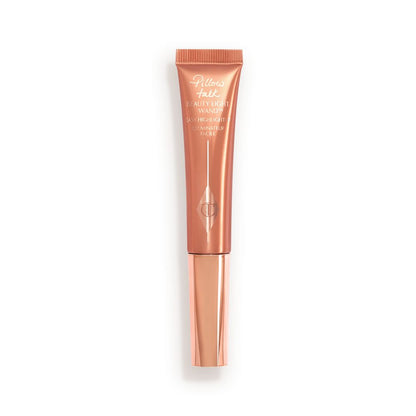a highlighter wand, packaged in a reflective, peachy-pink tube with a rose gold cap.