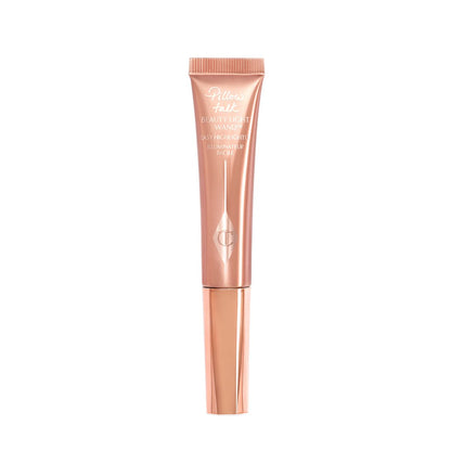A liquid highlighter wand in a pearlescent rose-gold plastic tube with its nude-pink box next to it.