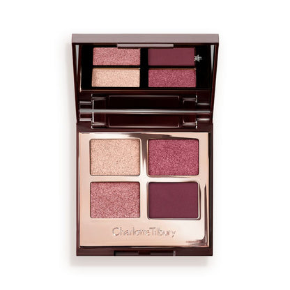 A mirrored-lid, quad eyeshadow palette with eyeshadows in shades of pink, plum, and champagne.
