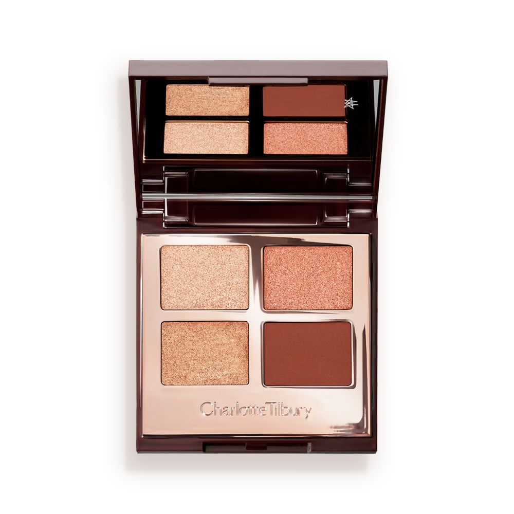 An open, mirrored-lid, quad eyeshadow palette with matte and shimmery eyeshadows in shades of copper and champagne.
