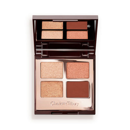 An open, mirrored-lid, quad eyeshadow palette with matte and shimmery eyeshadows in shades of copper and champagne.