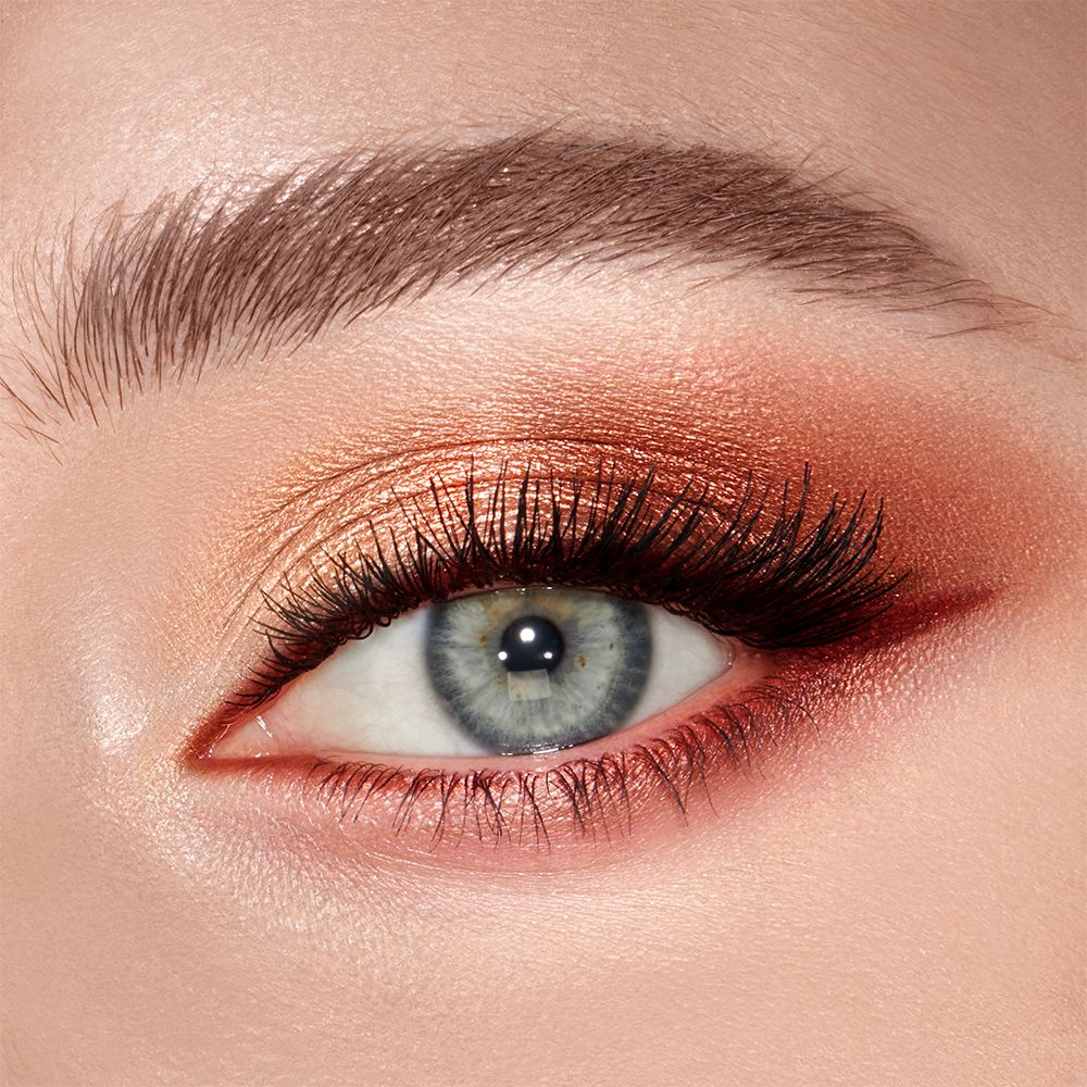 Close-up of a shimmery, copper and gold eye look on a fair-tone model with grey eyes.