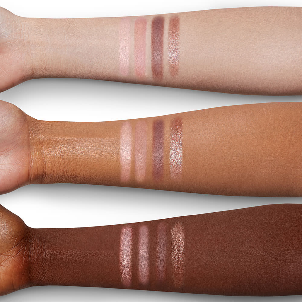 Arm swatches of a quad eyeshadow palette with light pink, dark pink, dark brown, and light brown eyeshadow.