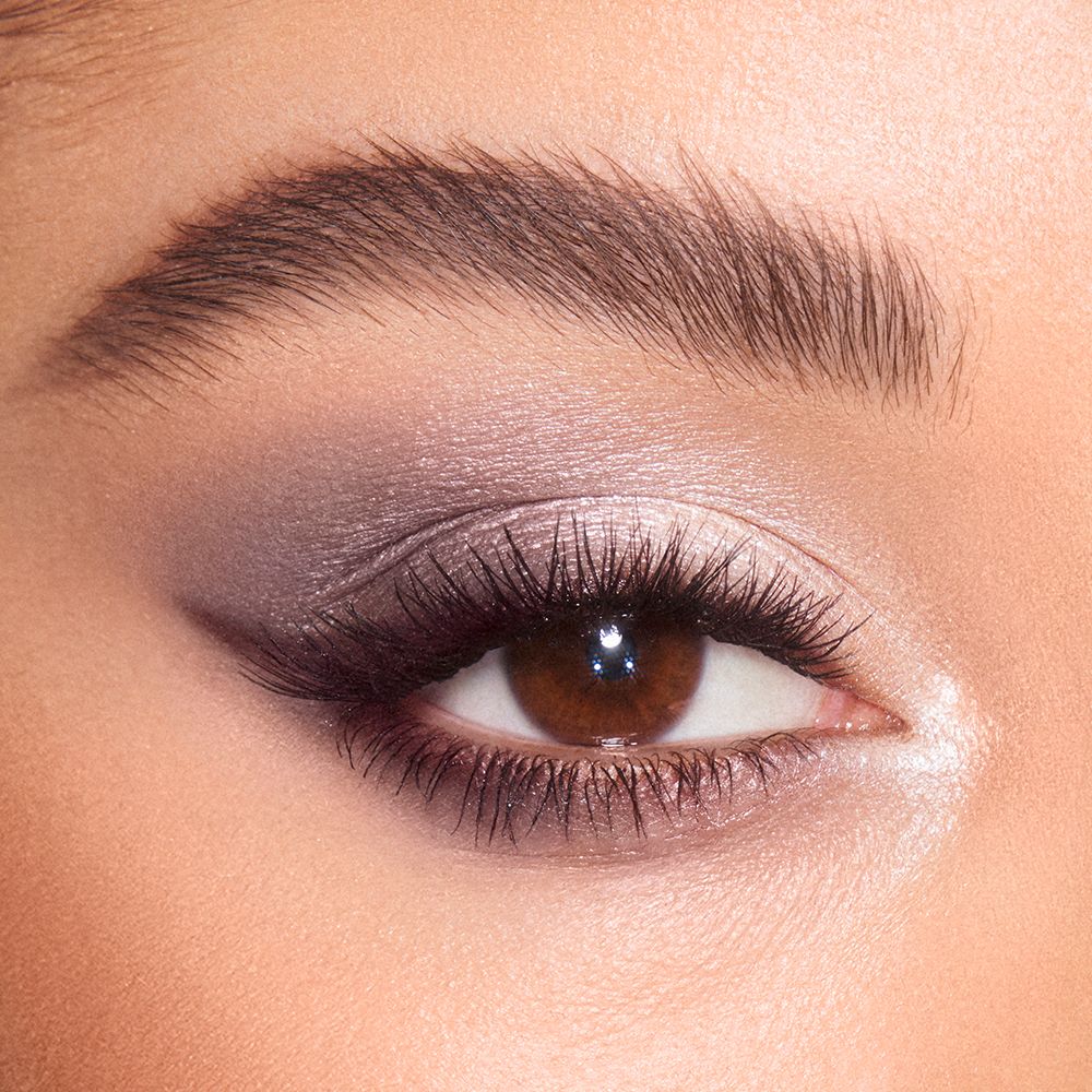 Close-up of a light-tone model's brown eye with shimmery grey, pearl, and silver eye makeup.