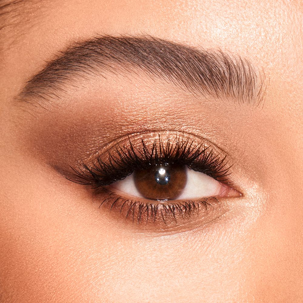 Close-up of a light-tone model's brown eye with shimmery light brown, dark brown, and cream-colour eye makeup.