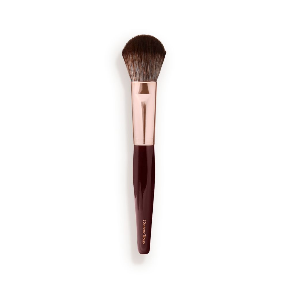 A bronzer and blush brush with soft bristles and rose gold and dark crimson handle.