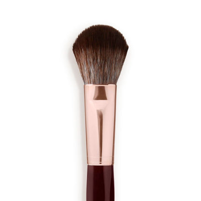 Close-up of a bronzer and blush brush with dark brown and grey bristles with a rose-gold and dark crimson handle.