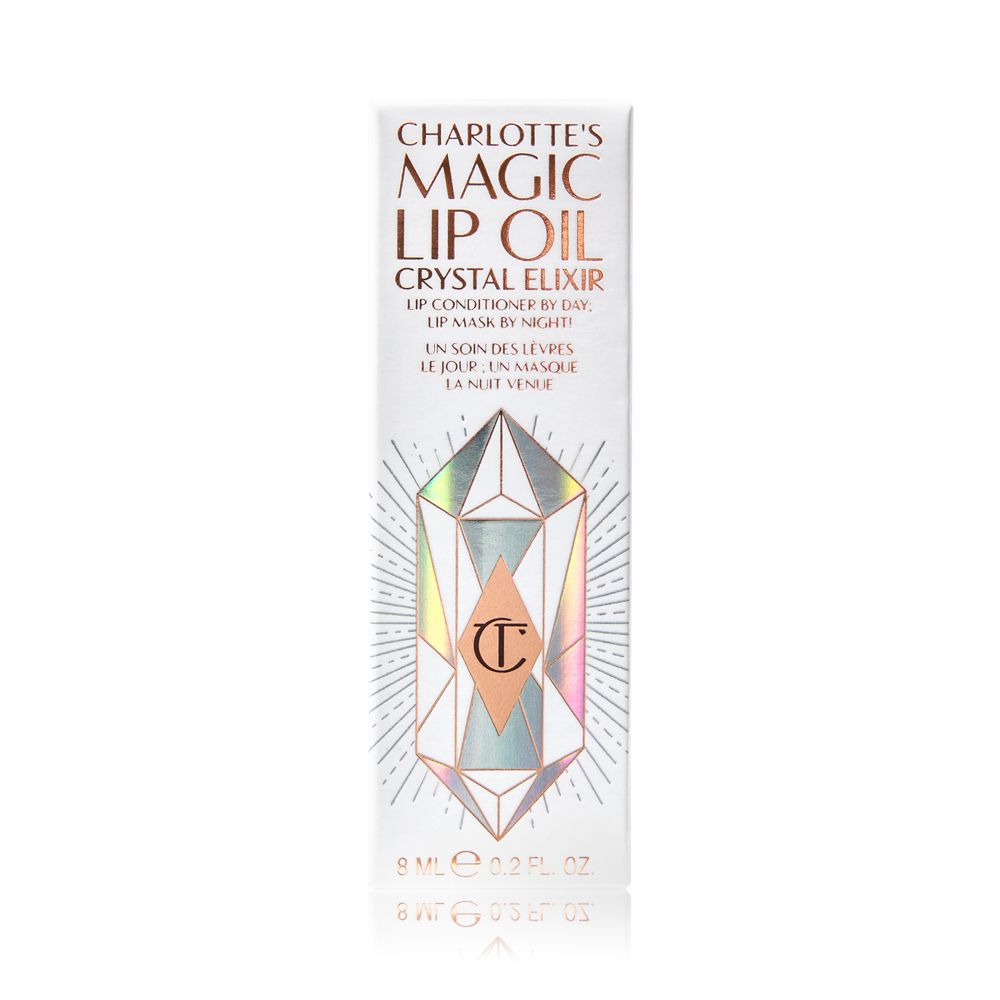A white-coloured lip oil box with shiny, geometric patterns on it, and Magic Lip Oil written on it in rose gold colour.