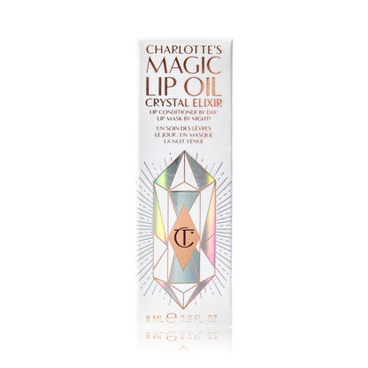 A white-coloured lip oil box with shiny, geometric patterns on it, and Magic Lip Oil written on it in rose gold colour.