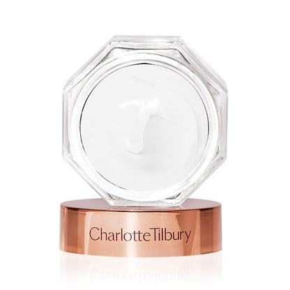 Thick, pearly-white cream in an open glass jar with its rose-gold-coloured lid next to it.