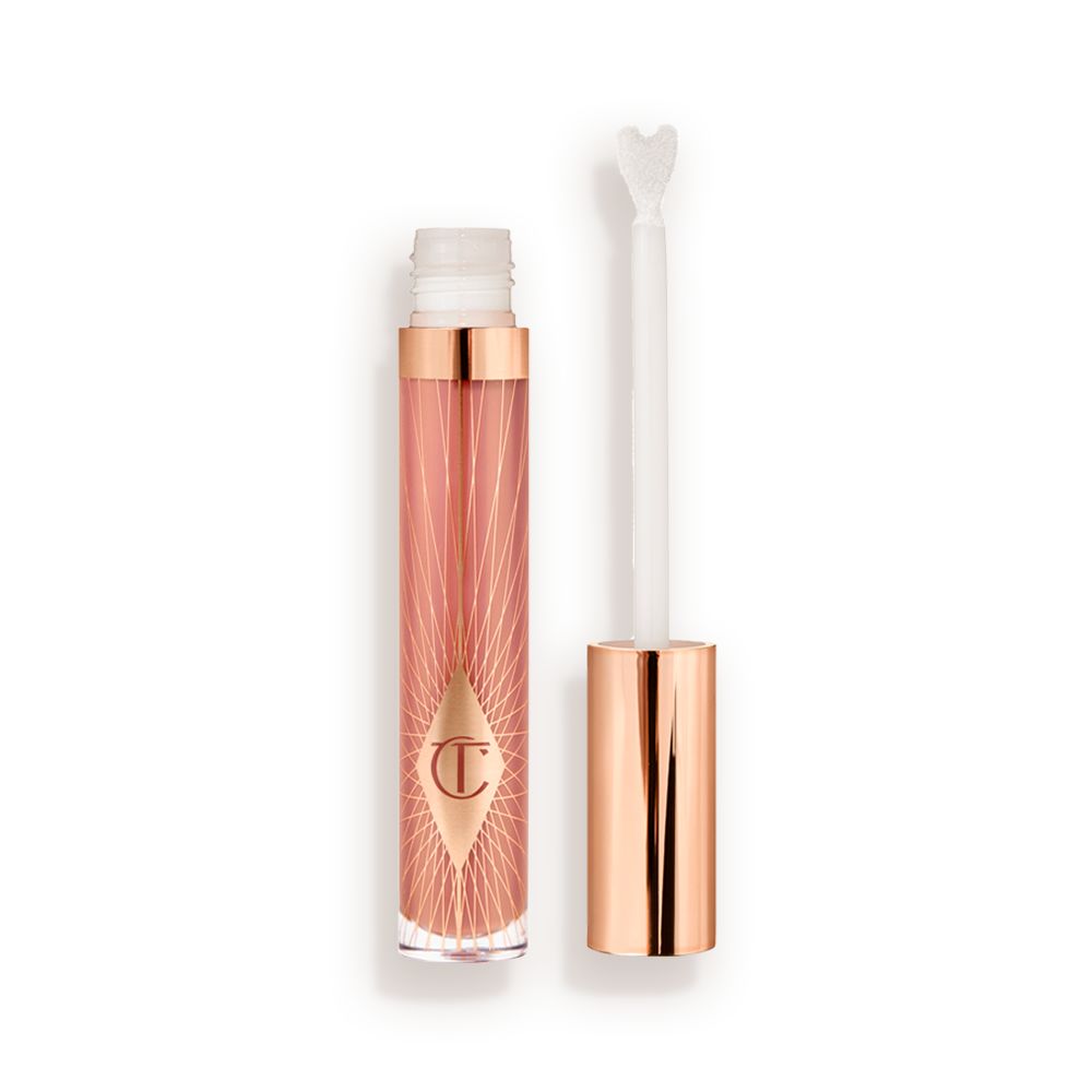 an opened, standard-sized, nude-pink lip gloss with a heart-shaped applicator with a rose gold lid next to it.