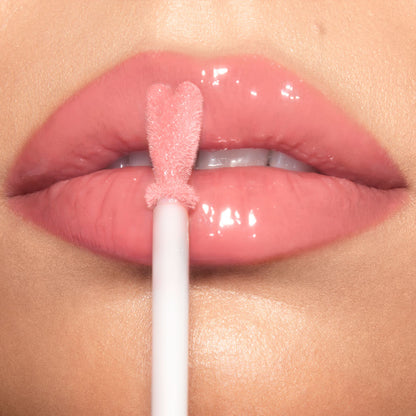 Lips close-up of a light-tone model wearing a high-shine, nude-pink lip gloss.