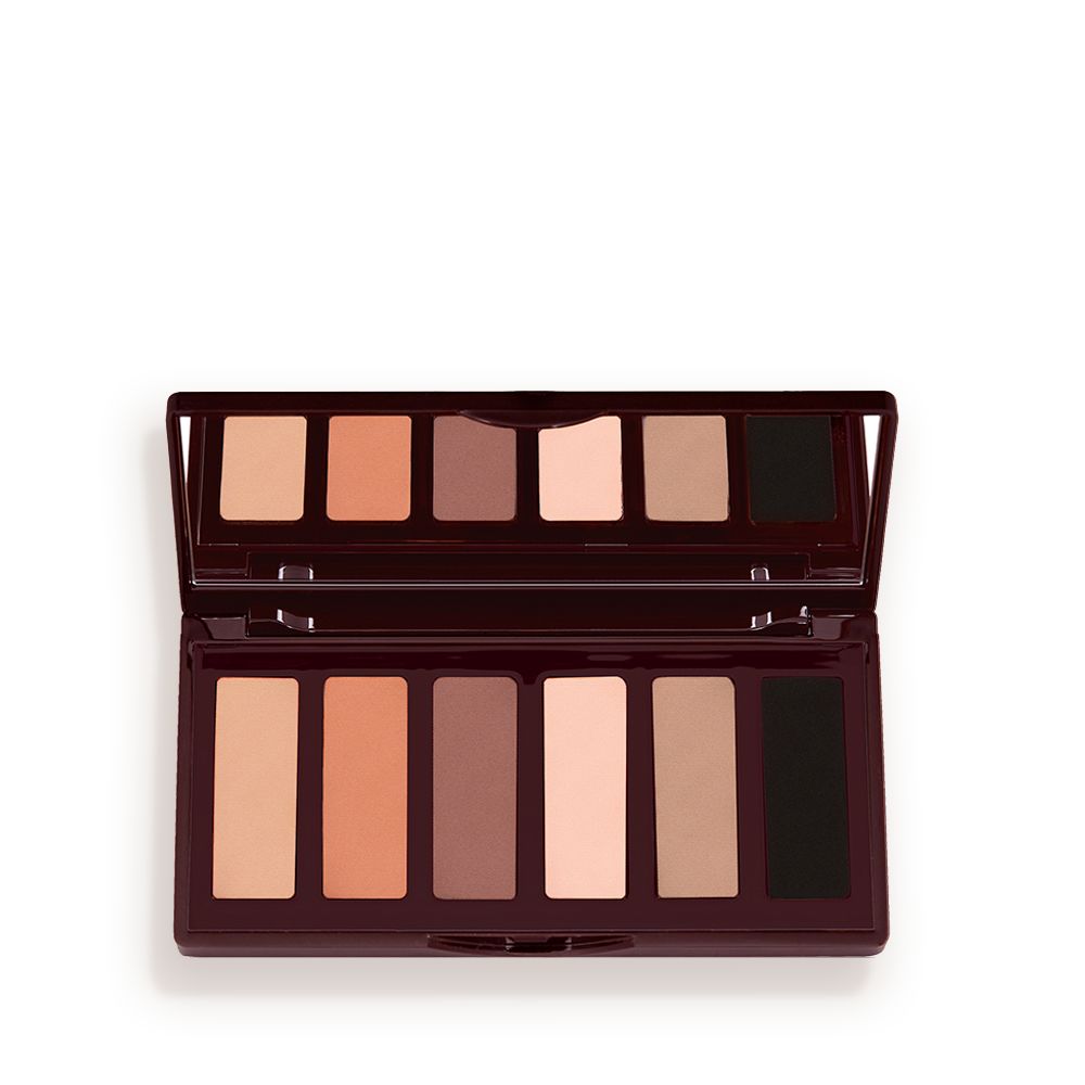 An open, mirrored-lid six-pan eyeshadow palette with matte eyeshadows in brown, peach, and beige shades.