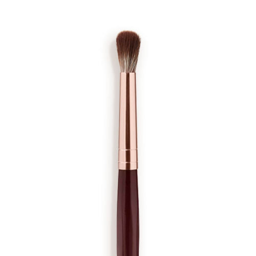 Close-up of an eyeshadow blending brush with soft bristles and a rose-gold and dark crimson handle.
