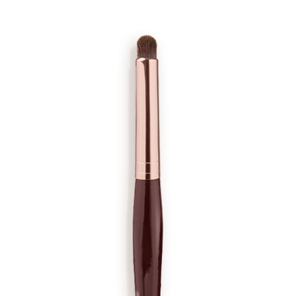 Close-up of an eyeshadow smudging brush with soft bristles and a rose-gold and dark crimson handle.