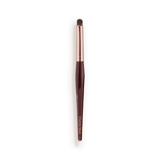 An eyeshadow smudging brush with soft bristles and rose gold and dark crimson handle.