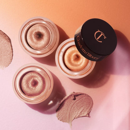 Three, petite, open pots filled with shimmery cream eyeshadows in nude, bronze, and rose gold.