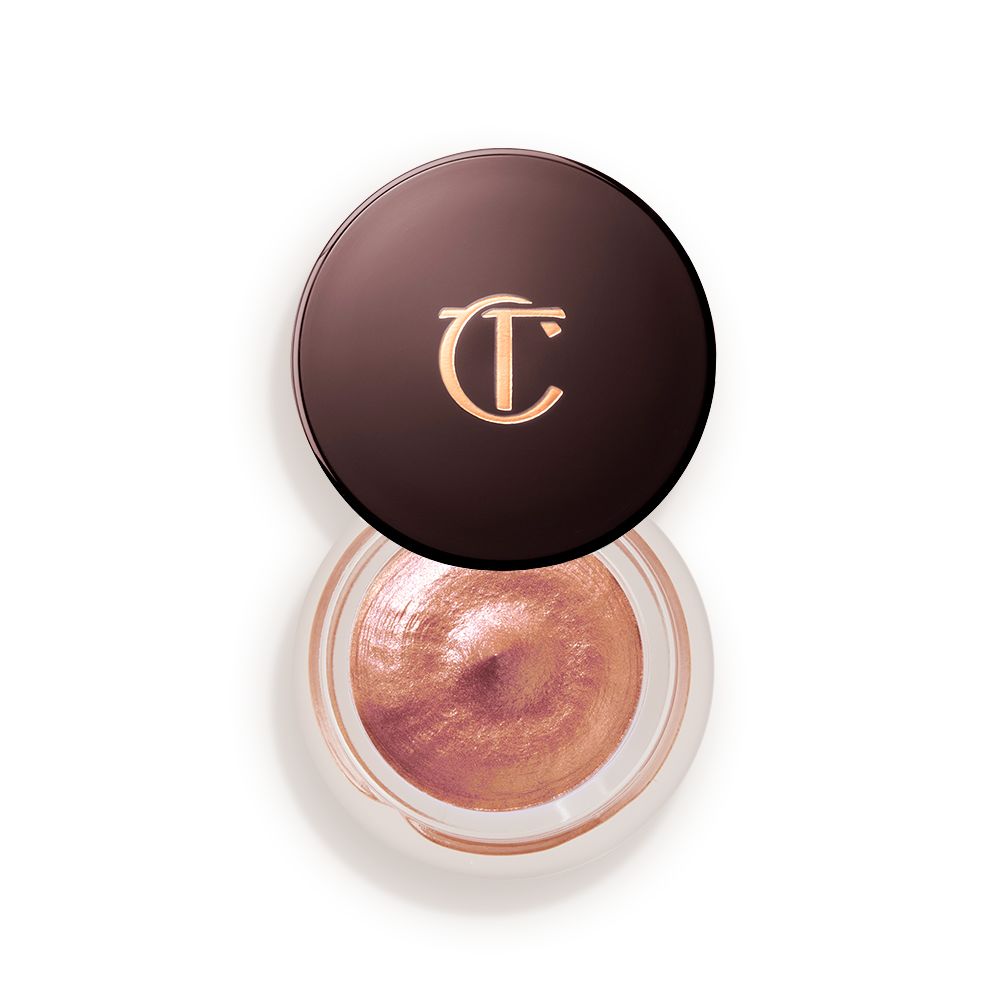 A warm sunset gold cream eyeshadow in a petite, open glass pot with a dark brown lid.