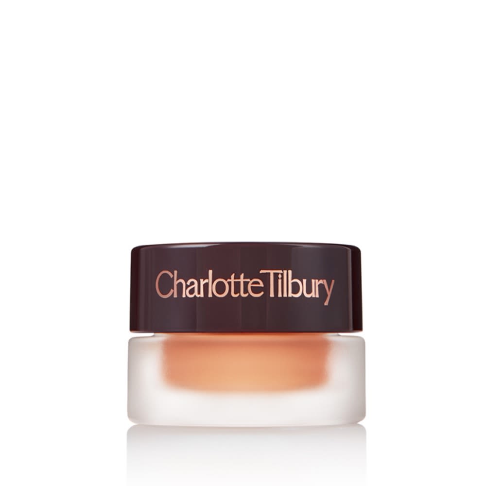 A warm sunset gold cream eyeshadow in a petite glass pot with a dark brown lid.