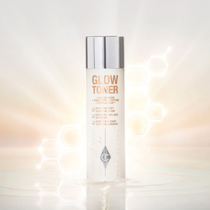 A large, clear bottle filled with luminous, cream-coloured watery toner with a silver-coloured lid.