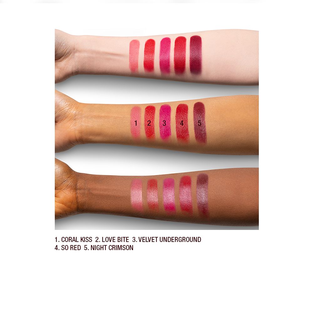 Light, tan, and deep-skin arm swatches of satin-finish lipsticks in shades of light, warm, and dark red.