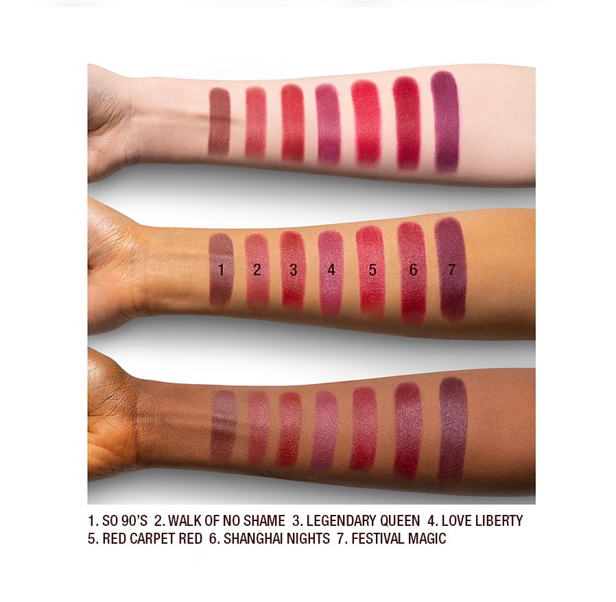 Arm swatches on fair, medium, and dark tone models of matte lipsticks in shades of red, plum, and burgundy.