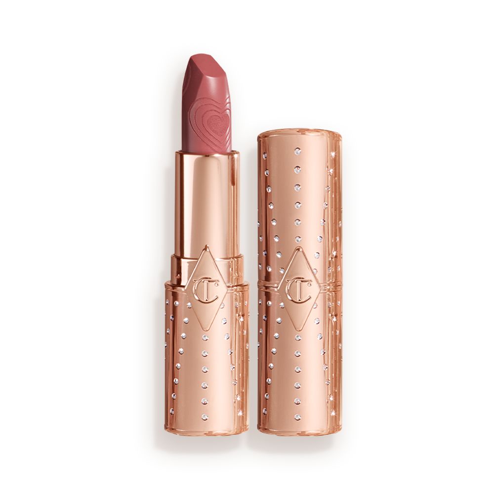 An open, rose-bud pink lipstick in a metallic, golden-coloured tube with its lid next to it.