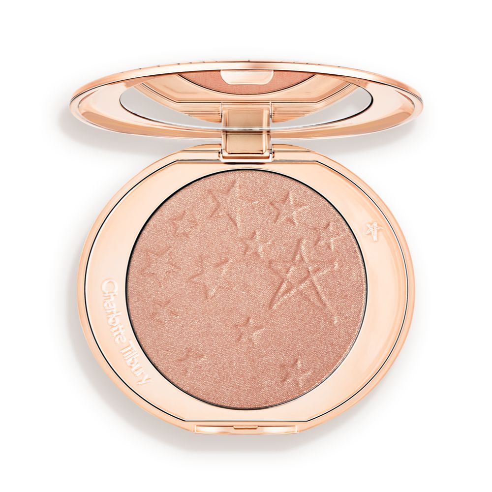 An open highlighter powder compact with a mirrored lid, in a shimmery rose gold shade.