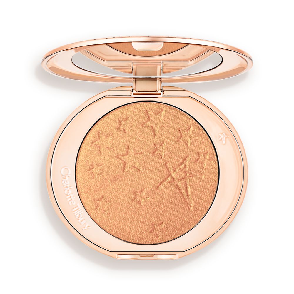 An open highlighter powder compact in a true gold shade with a mirrored lid.
