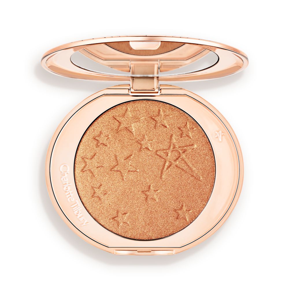 An open highlighter powder compact with a mirrored lid, in a shimmery copper-gold shade.