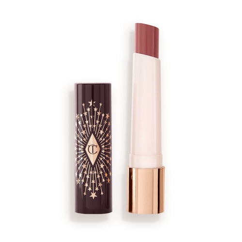 An open, moisturizing lipstick lip balm in a nude pink shade with a black and gold-coloured cover.